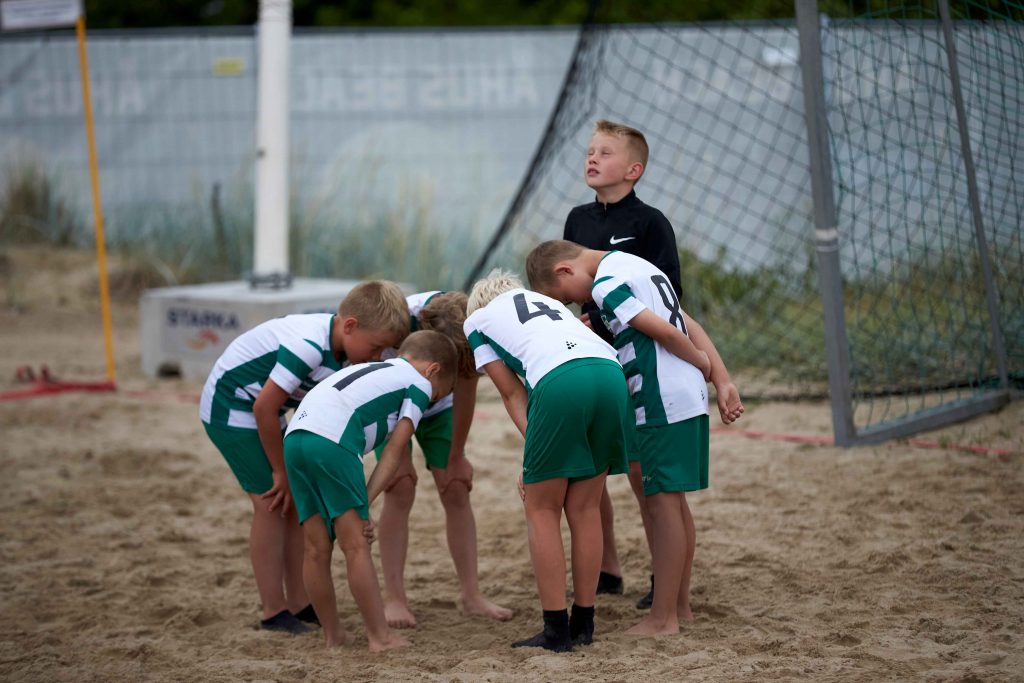 Unga pojkar samlade för tacktik snack inför match på Åhus Beachfotboll festival