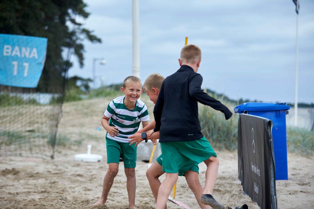 Lekande barn i matchkläder på Åhus Beachfotboll festival