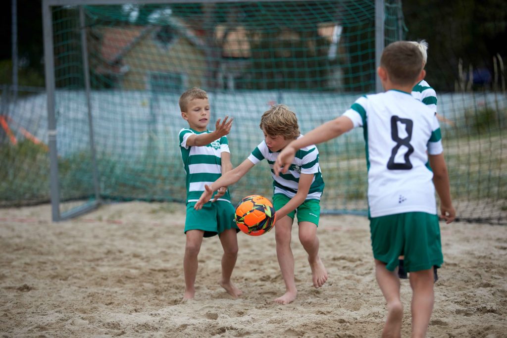 Fyra barn leker med fotboll på Åhus Beachfotboll festival