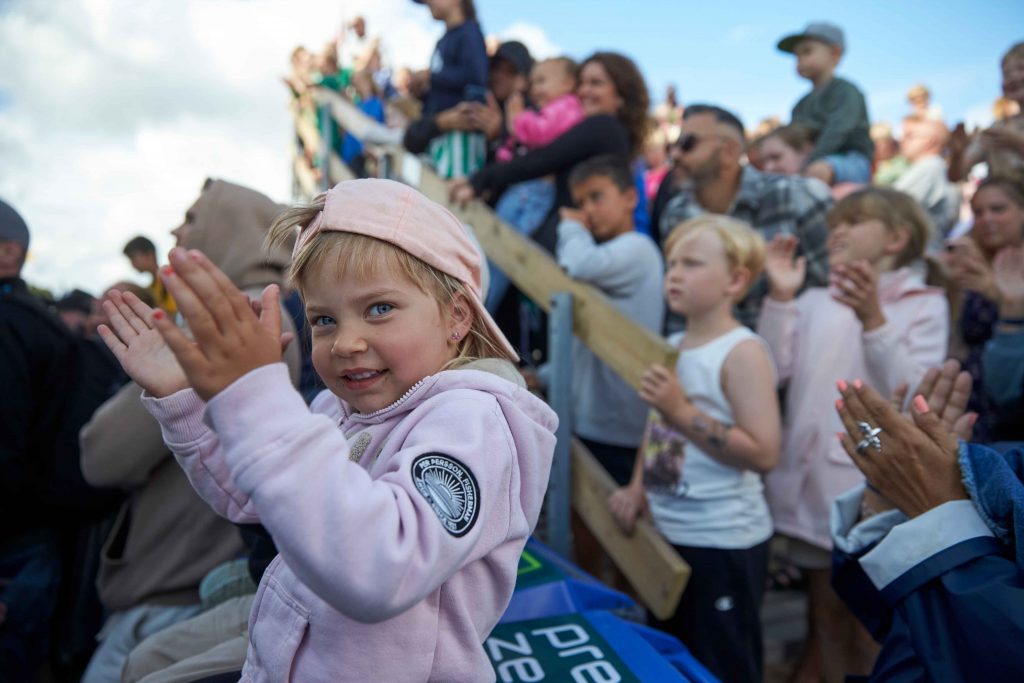 Applåderande liten flicka längst fram vid scenen på Åhus Beachfotboll festival