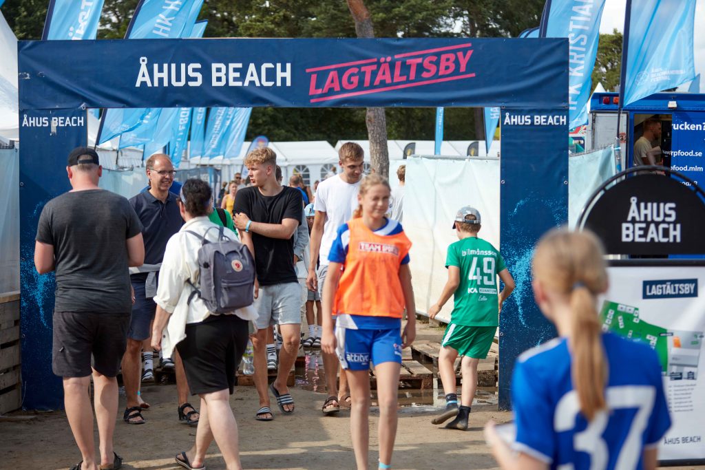 Spelare och tränare går genom passage till lagtältsbyn på Åhus beach Festival