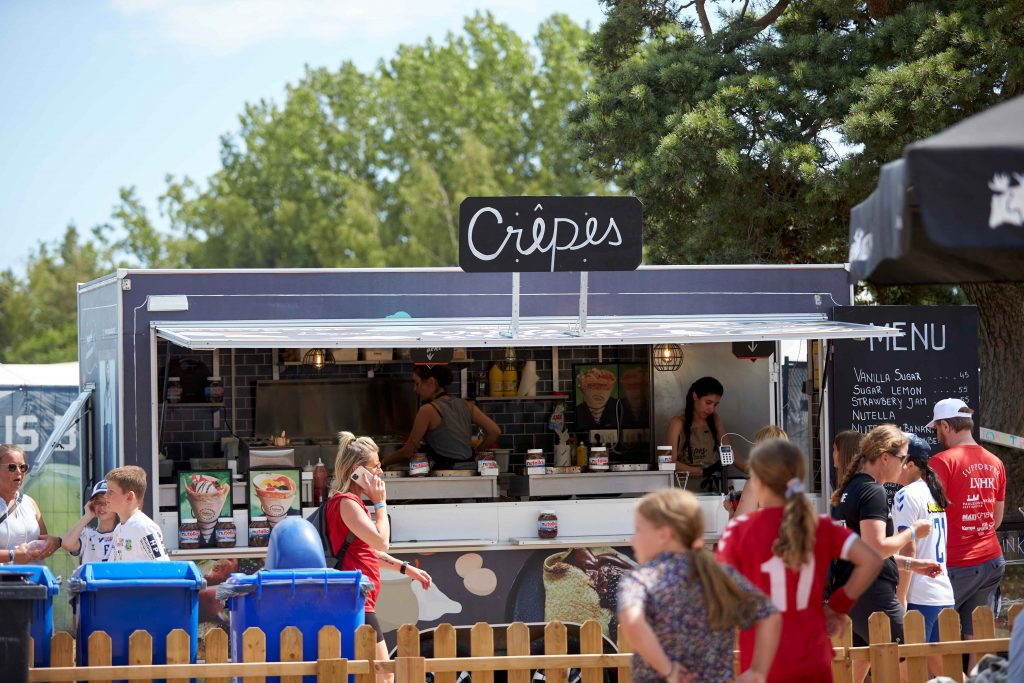 Foodtruck säljer Crepes på Åhus Beach Festival. Besökare står i kö framför Foodtruck.