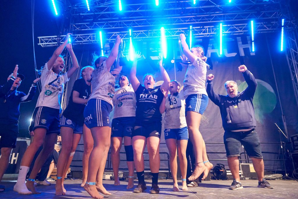 Glada kvinnliga vinnare på scen på centercourt på Åhus Beach festival