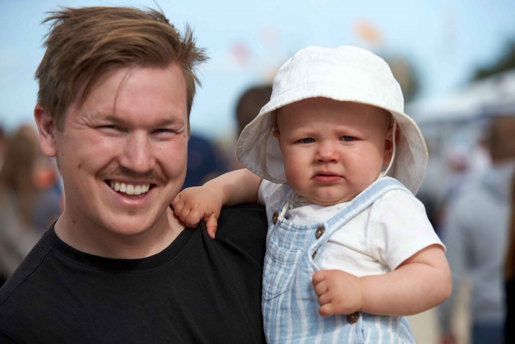 Besökande Pappa med bebis i famn under Åhus Beach festival