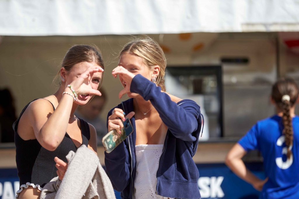 Tjejer gör love tecken med händerna på Åhus Beach festival