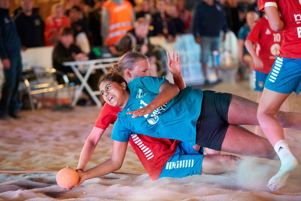 Närkamp när tjej försöker skjuta bollen på mål på Åhus Beach handbolls festival