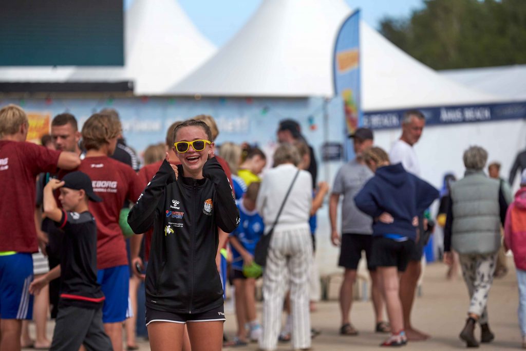 Glad tjej med solglasögon på Åhus Beach handbolls festival